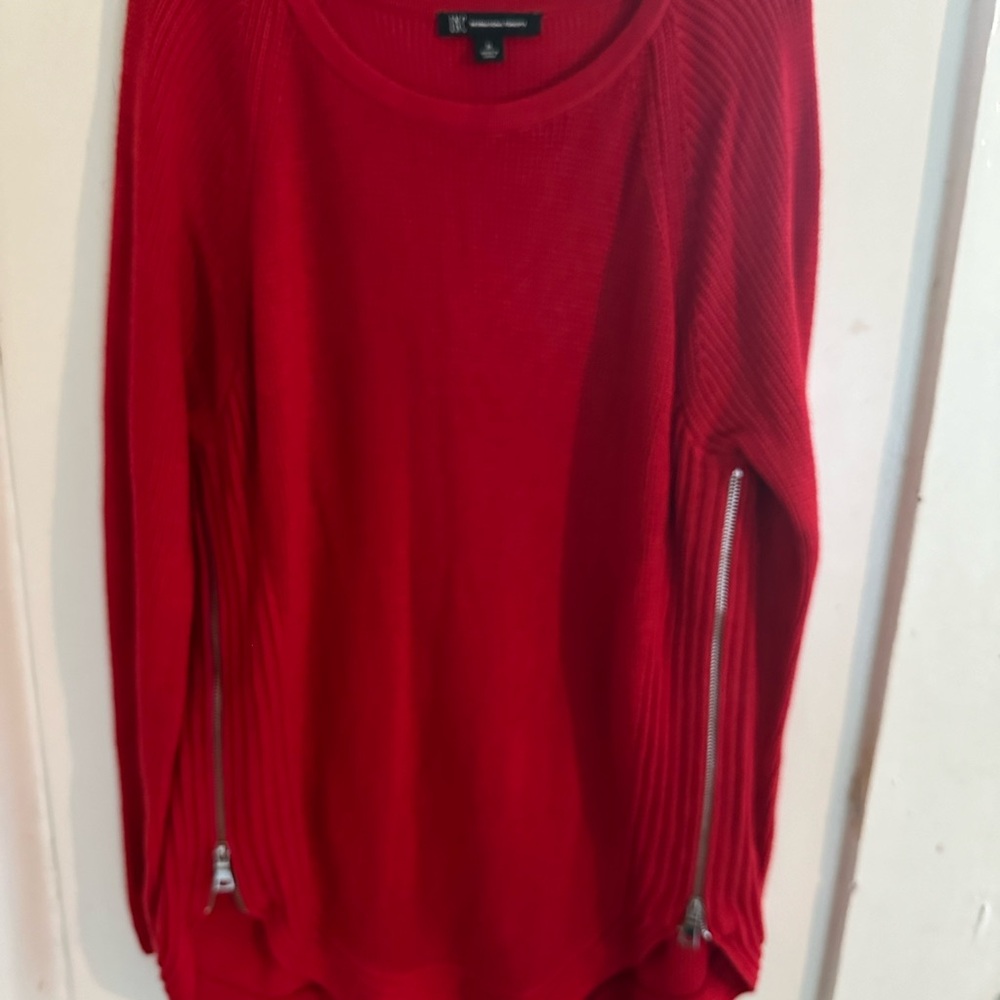 Women’s red sweater with functioning zippers on each side.